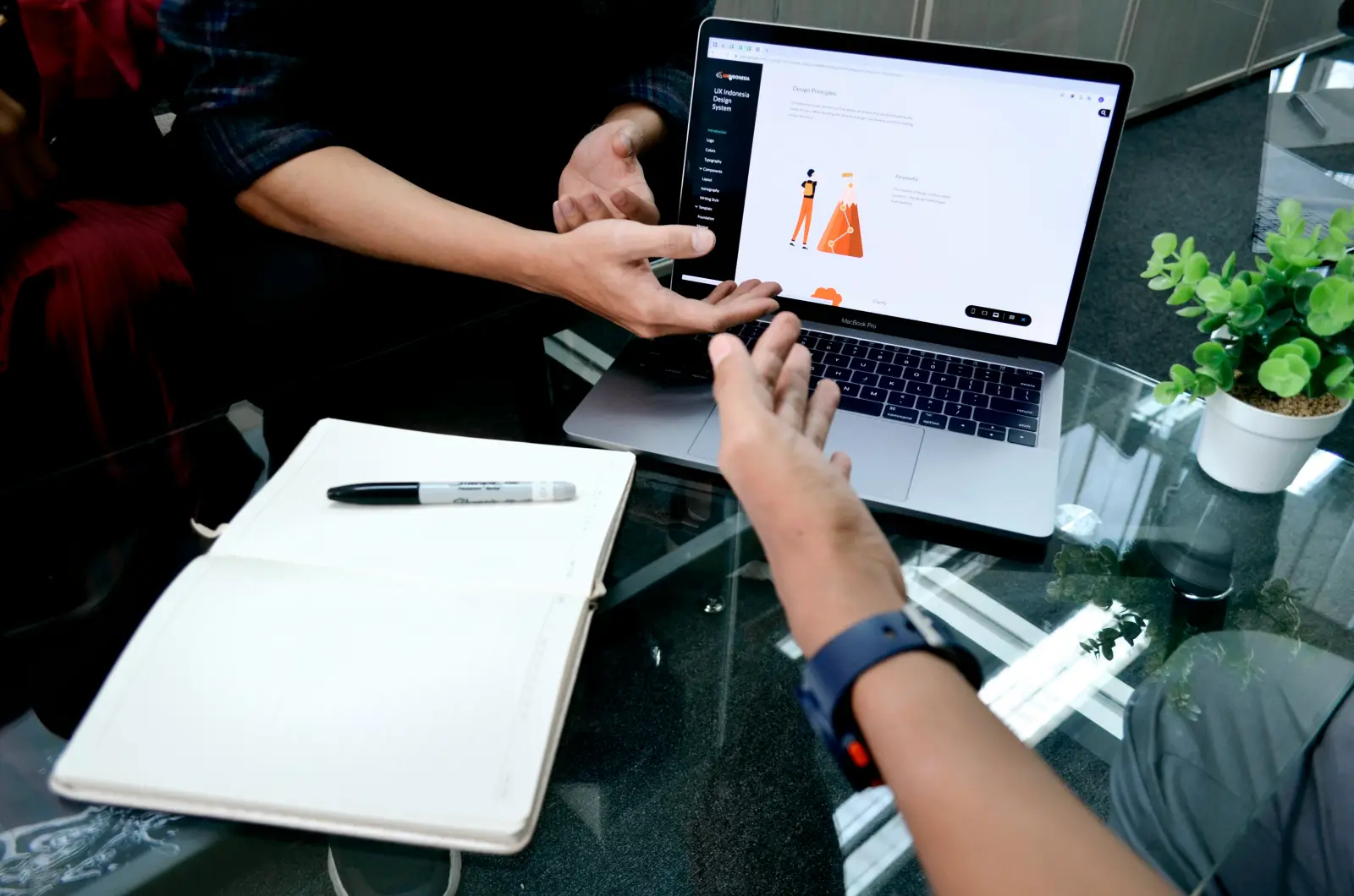 Two people reviewing a customer record on a laptop