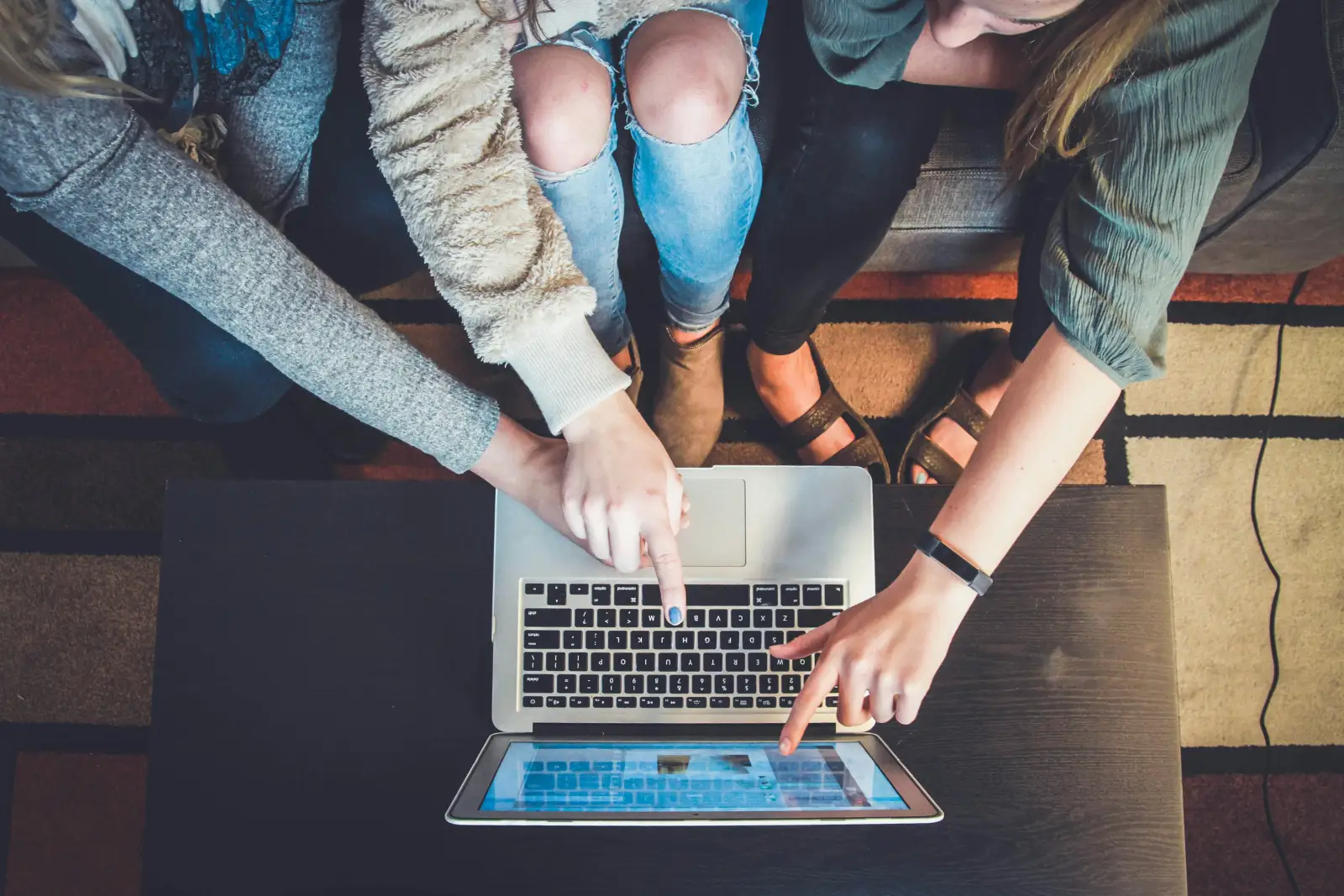 Three colleagues going over a customer record on a laptop